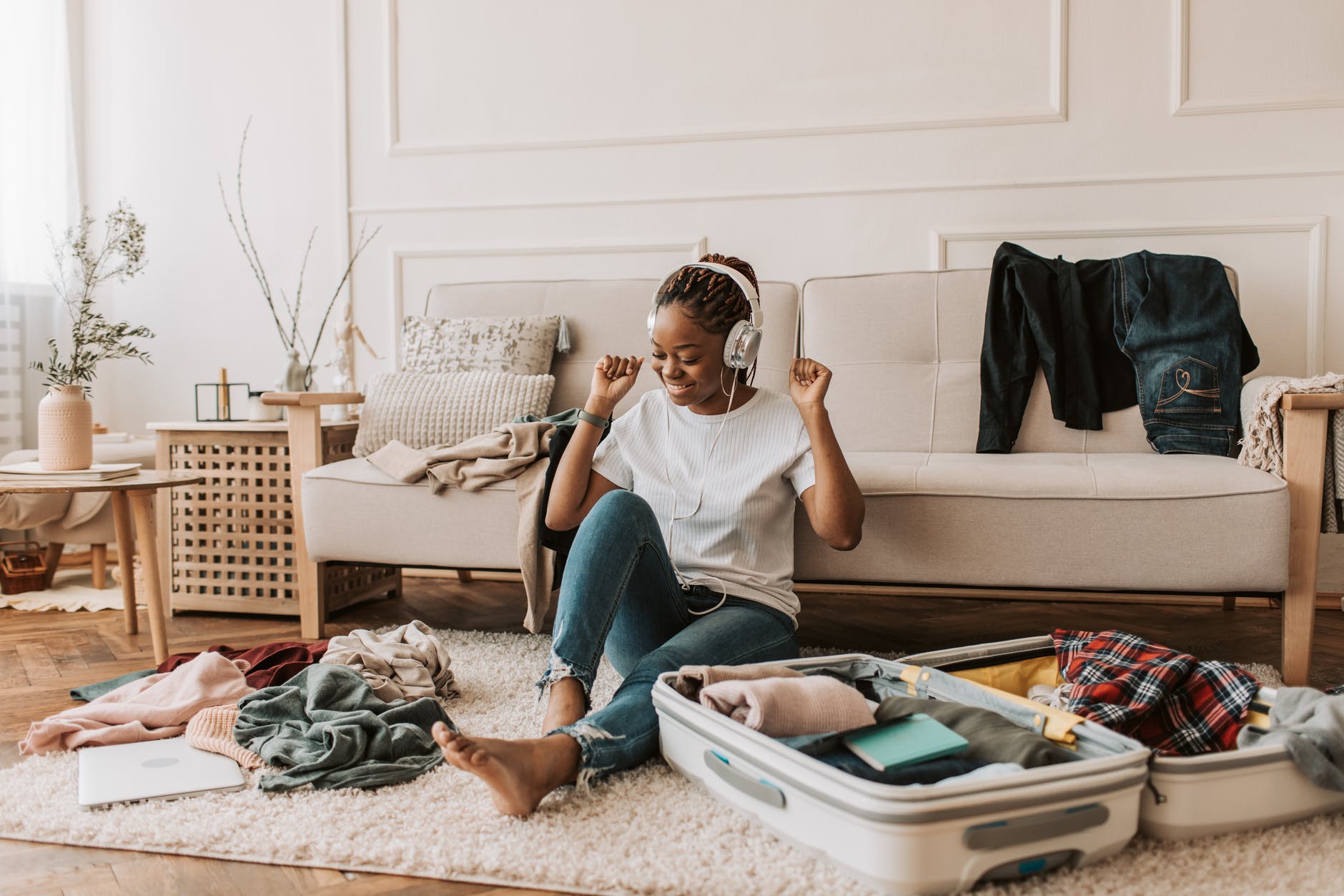 a woman listening on her headphones while packing