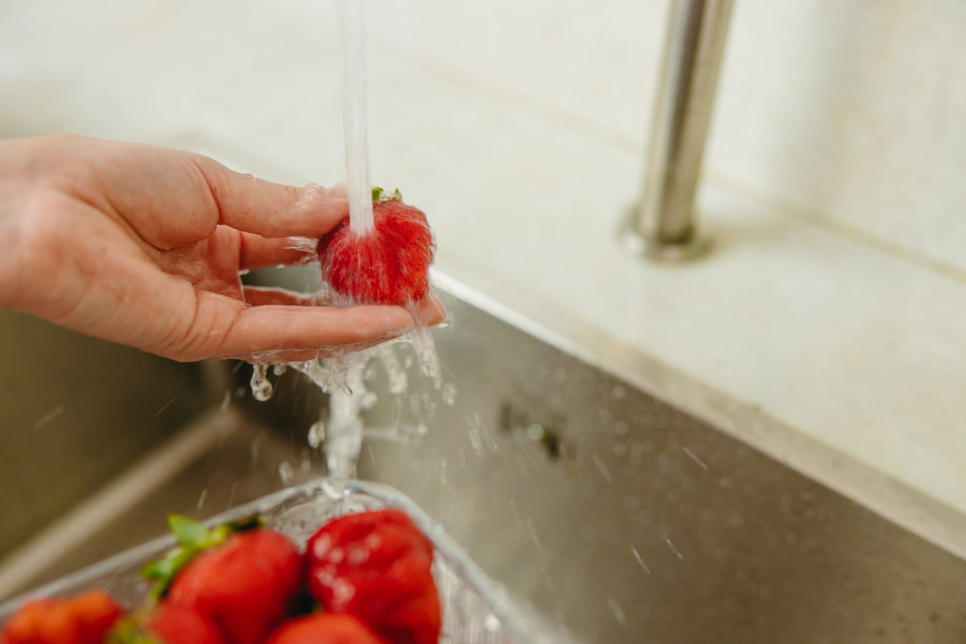 a person washing strawberries